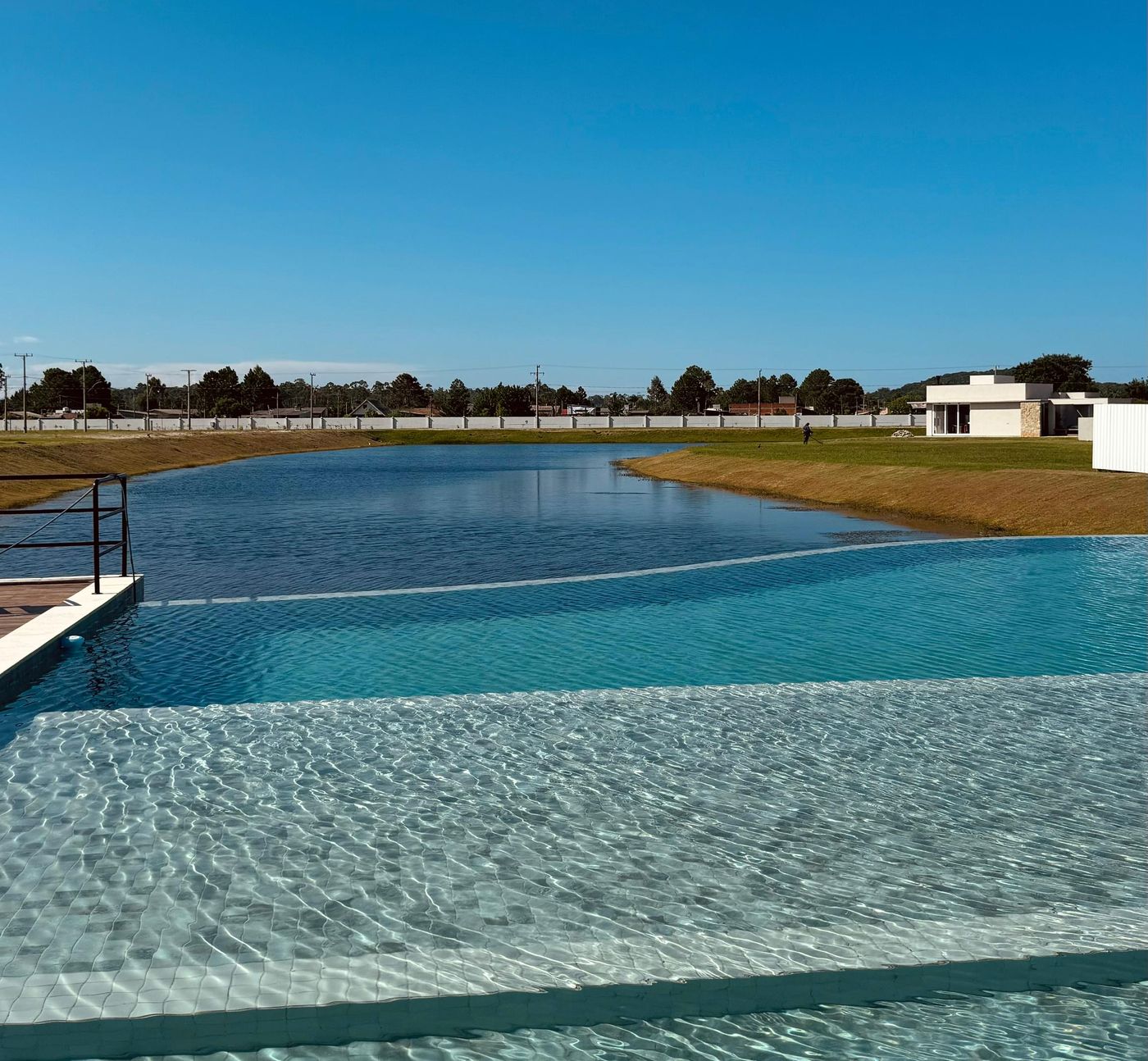 Piscina com borda infinita em frente ao lago