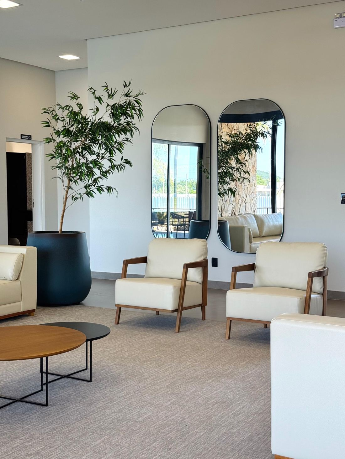 Sala de estar do clube com poltronas e espelhos